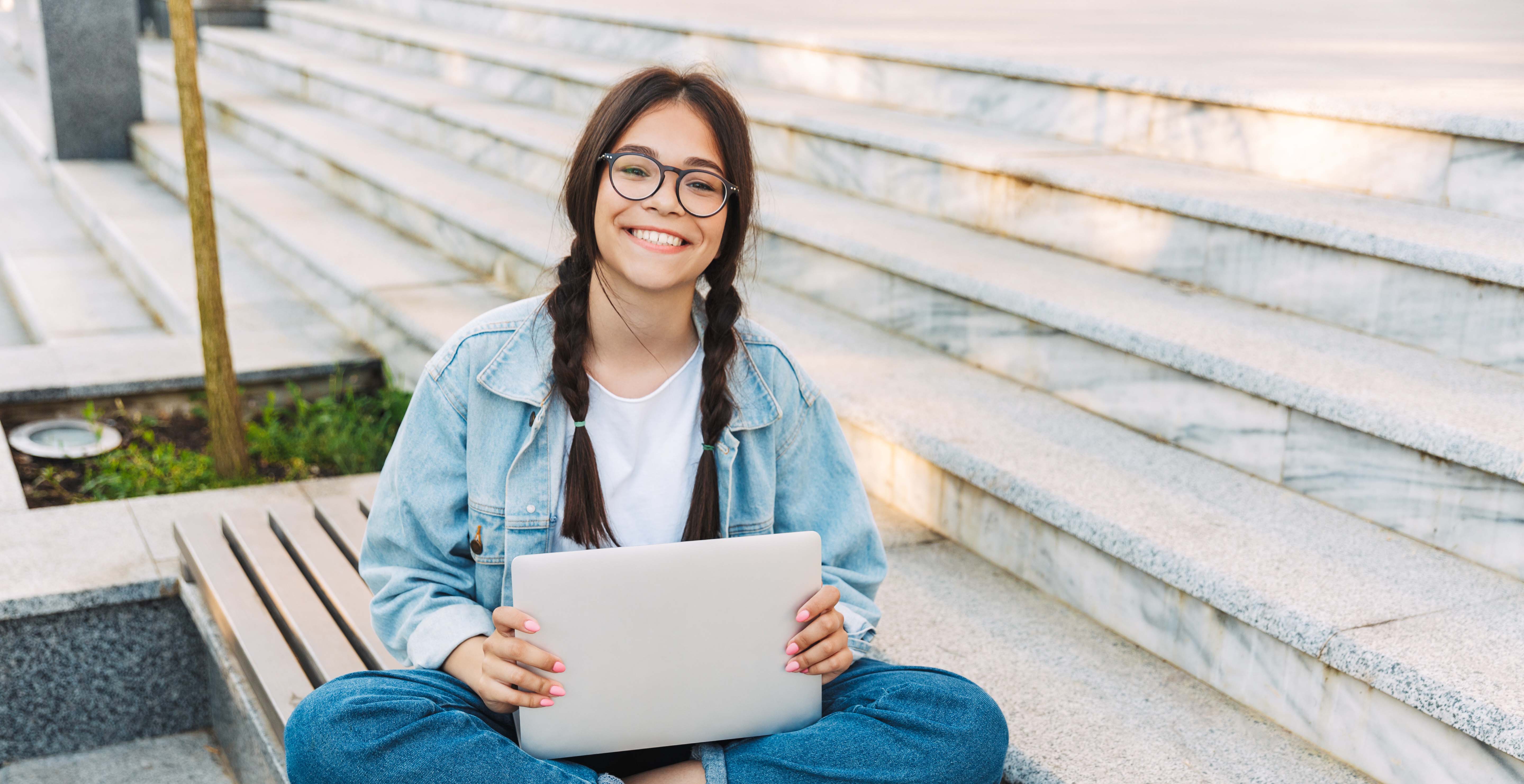 Student sitting outside with laptop