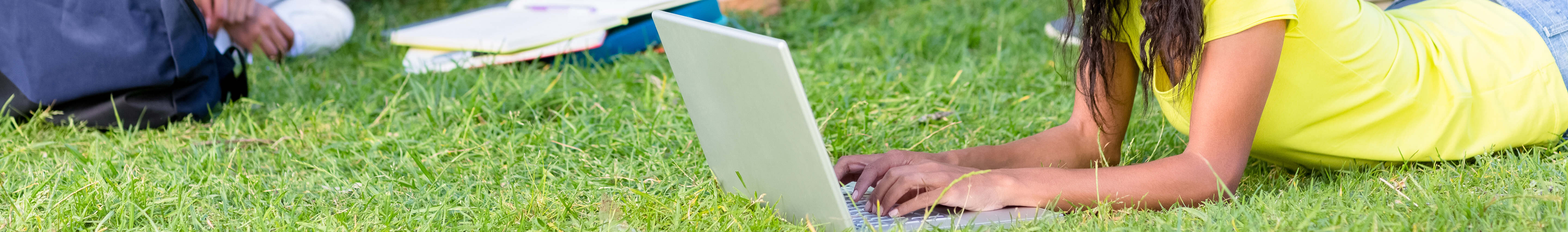 Students using a laptop to study outdoors