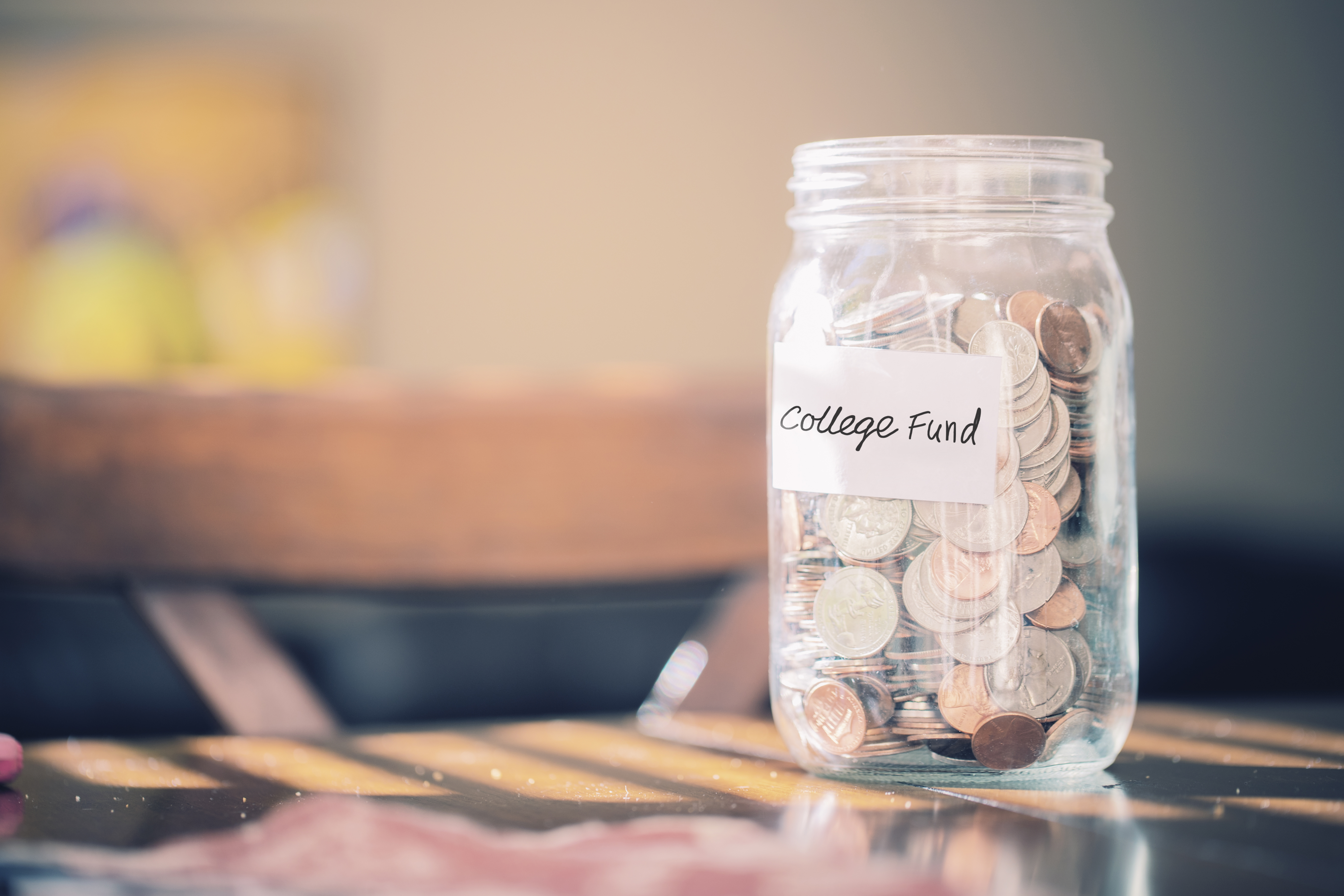 Jar of change labeled college fund in sun filled room